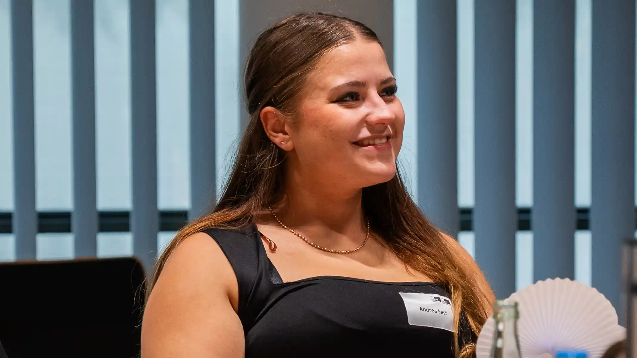 Lächelnde Auszubildende Andrea Fast mit Namensschild bei der Begrüßungsveranstaltung